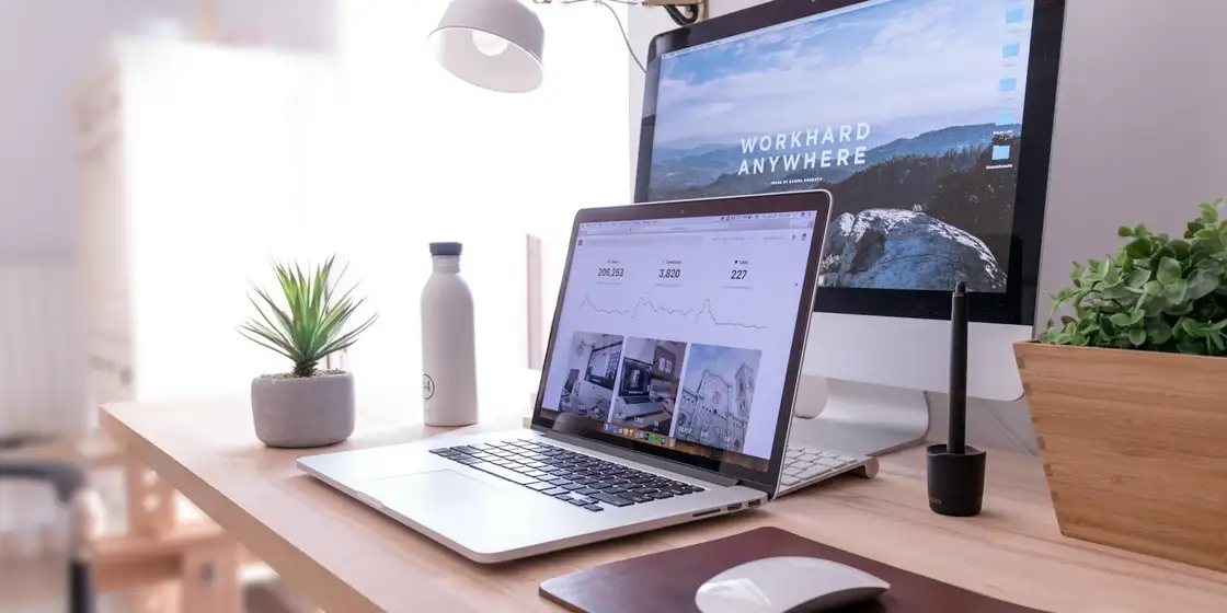 Escritorio con un portátil y un monitor mostrando una página web recién diseñada